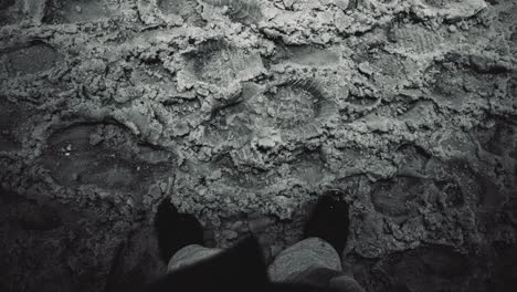 Man-Standing-with-Black-White-Shoes-in-Large-Flurry-of-Mushy-Vignette-Snow-Powder-Fall-with-Footprints-in-an-Northern-Winter-Urban-City-Population-Center