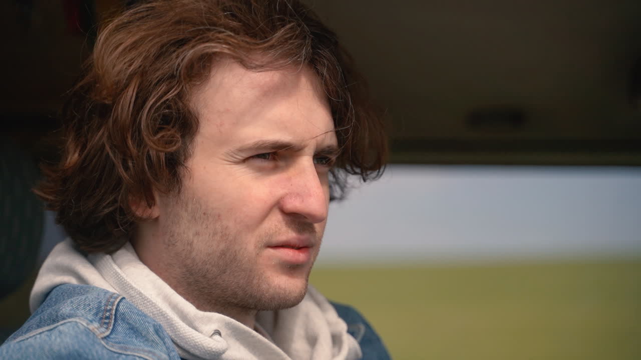 молодой парень смотрит в бинокль из автомобиля