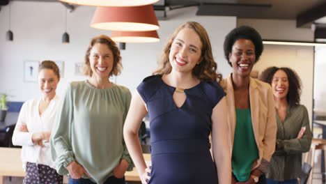 retrato de mujeres de negocios felices y diversas de pie en la oficina sonriendo a la cámara, en cámara lenta