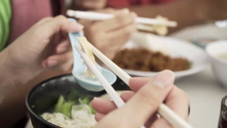 someone eating chinese food with chopsticks and a chinese spoon