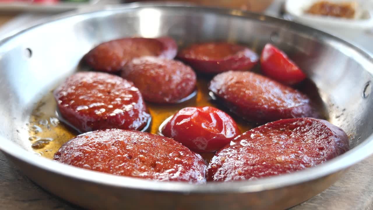 Sucuk in a pan with tomatoes