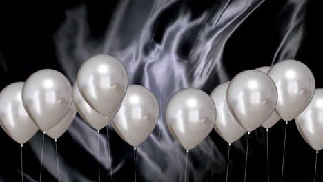 animation of silver balloons over black background