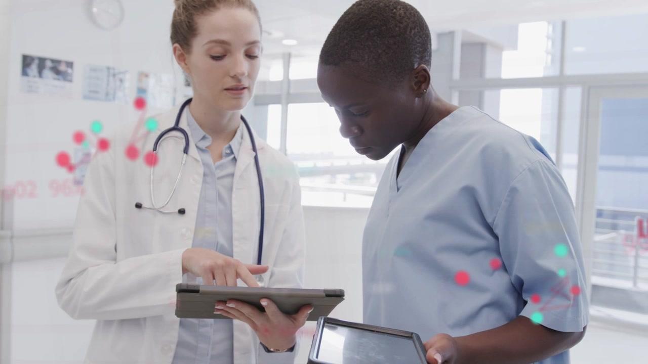 Medical clinician tapping tablet and showing red or teal data dots, guiding nurse confirming metrics