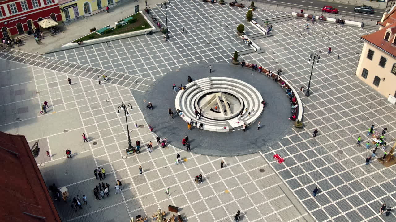 BRASOV, ROMANIA - APRILE 2022: Vista aerea con drone della Piazza del Consiglio a Brașov, Romania. Centro storico con il Museo di storia della contea e persone che si riposano