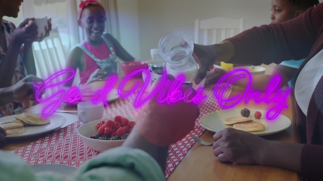 Animazione della scritta "solo buone vibrazioni" su una famiglia afroamericana che mangia insieme in cucina