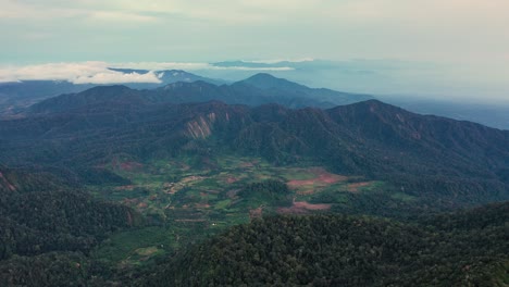 Aerial-view-of-mountainous-landscape-around-Mount-Sibayak-and-Mount-Sinabung-in-North-Sumatra,-Indonesia---camera-tilting-up