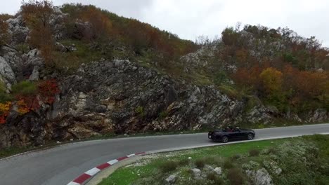 convertible car on scenic mountain road in autumn