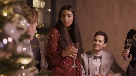 group of friends dressed in elegant clothes celebrating the new year's party, they stand around the bar counter while toasting and drinking champagne 1