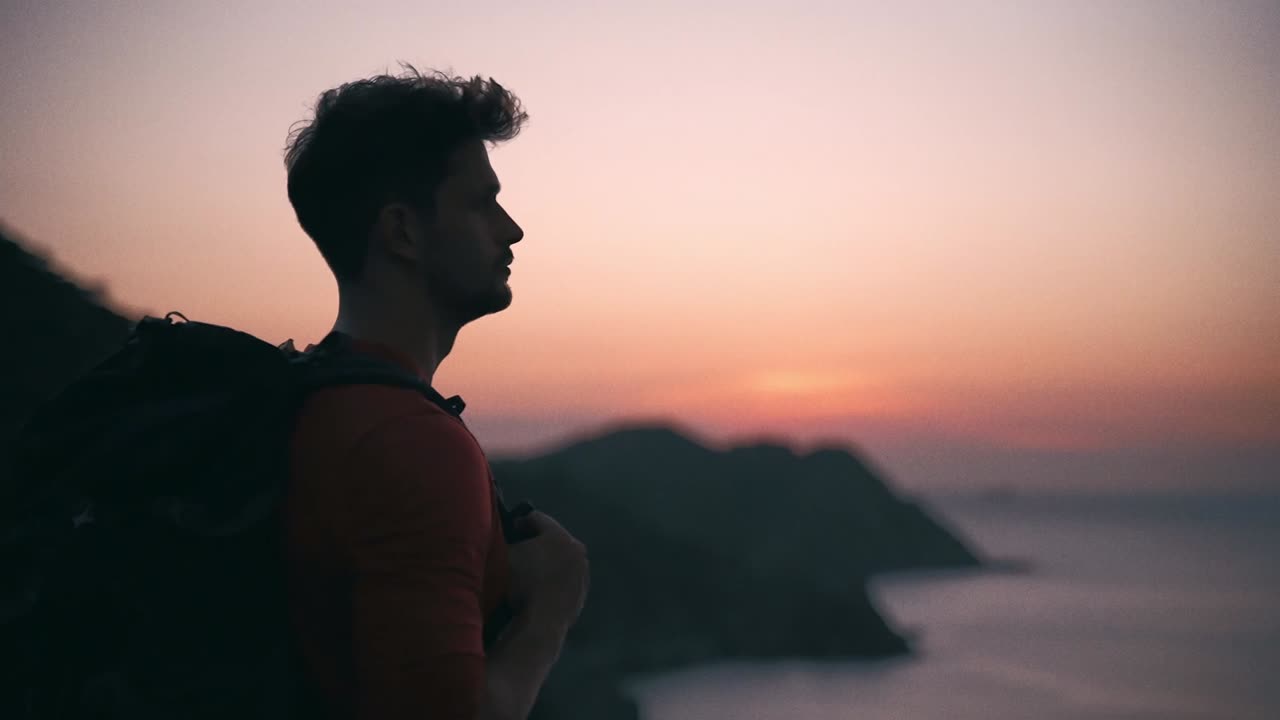 산과 바다를 따라 해가 지는 것을 보고 혼자 서 있는 배을 가진 어린 소년