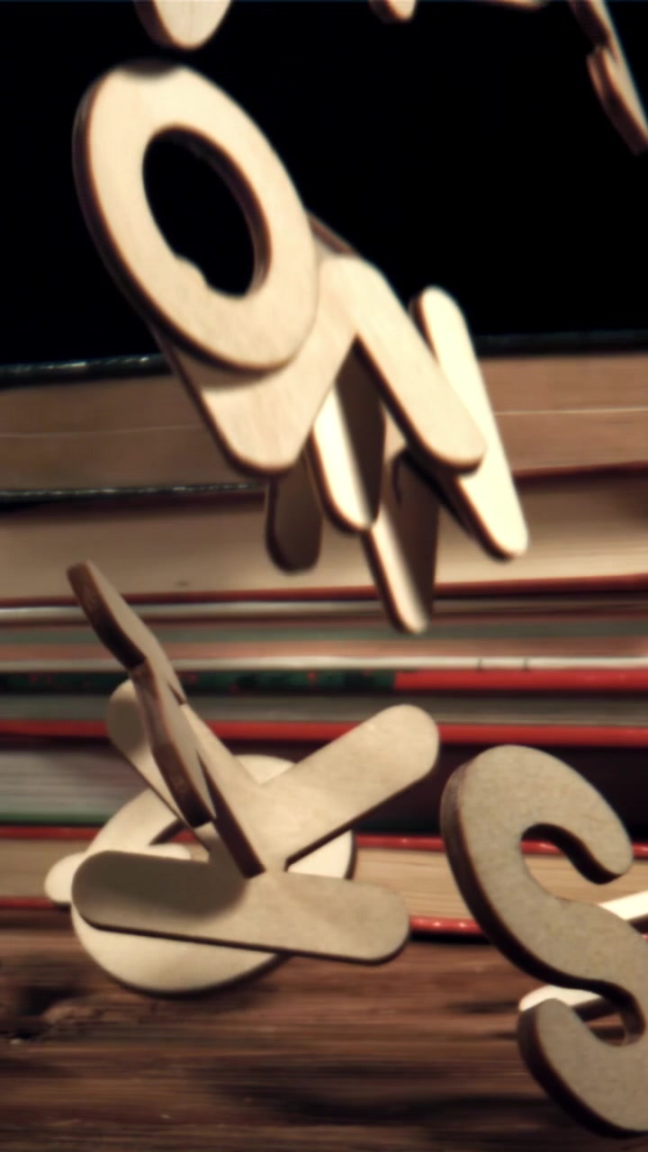 Lettere dell'alfabeto in legno che cadono su un tavolo con libri