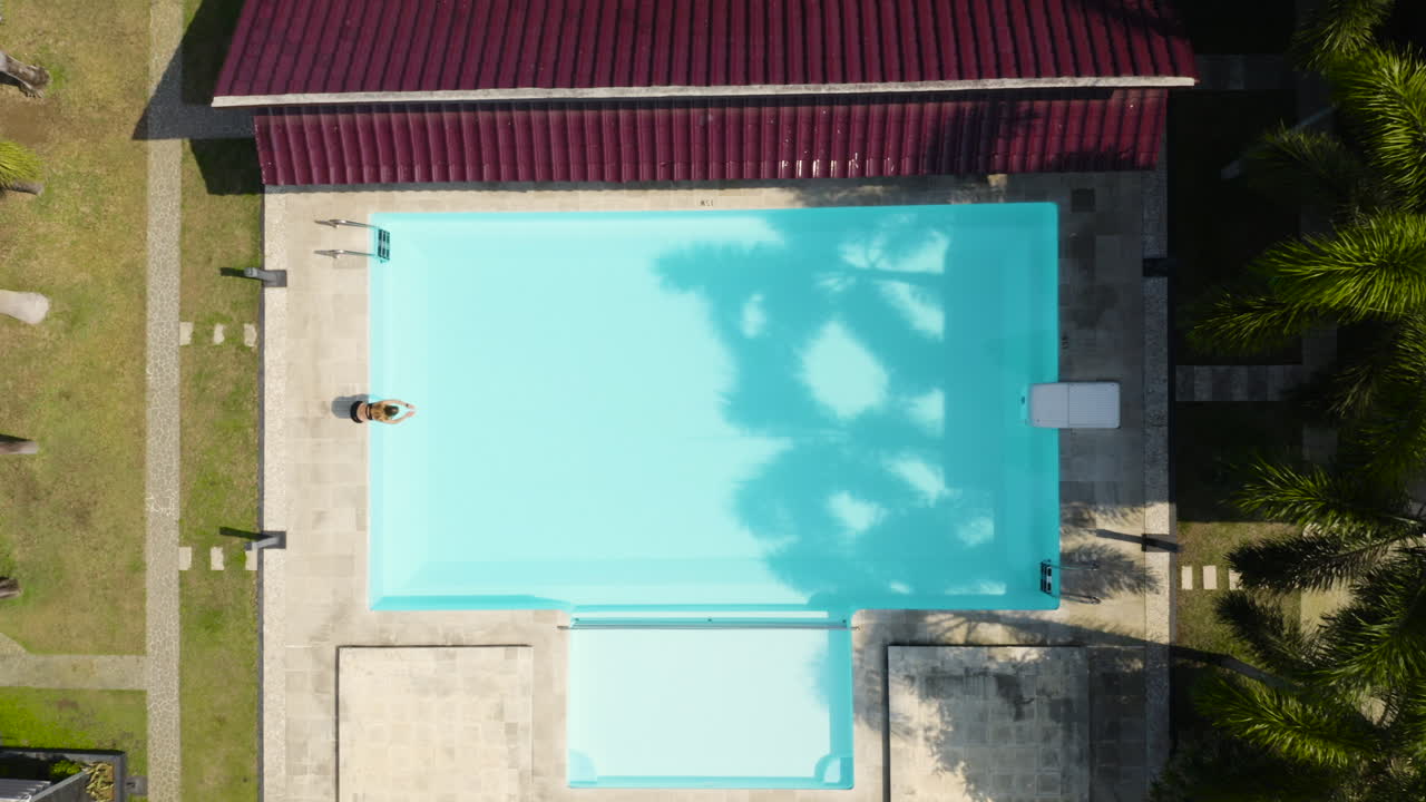 Person Swimming in a Tropical Resort Pool