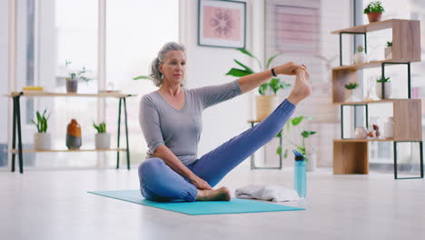 Ältere-Frau-Macht-Yoga-Auf-Einer-Matte-In-Ihrem-Wohnzimmer