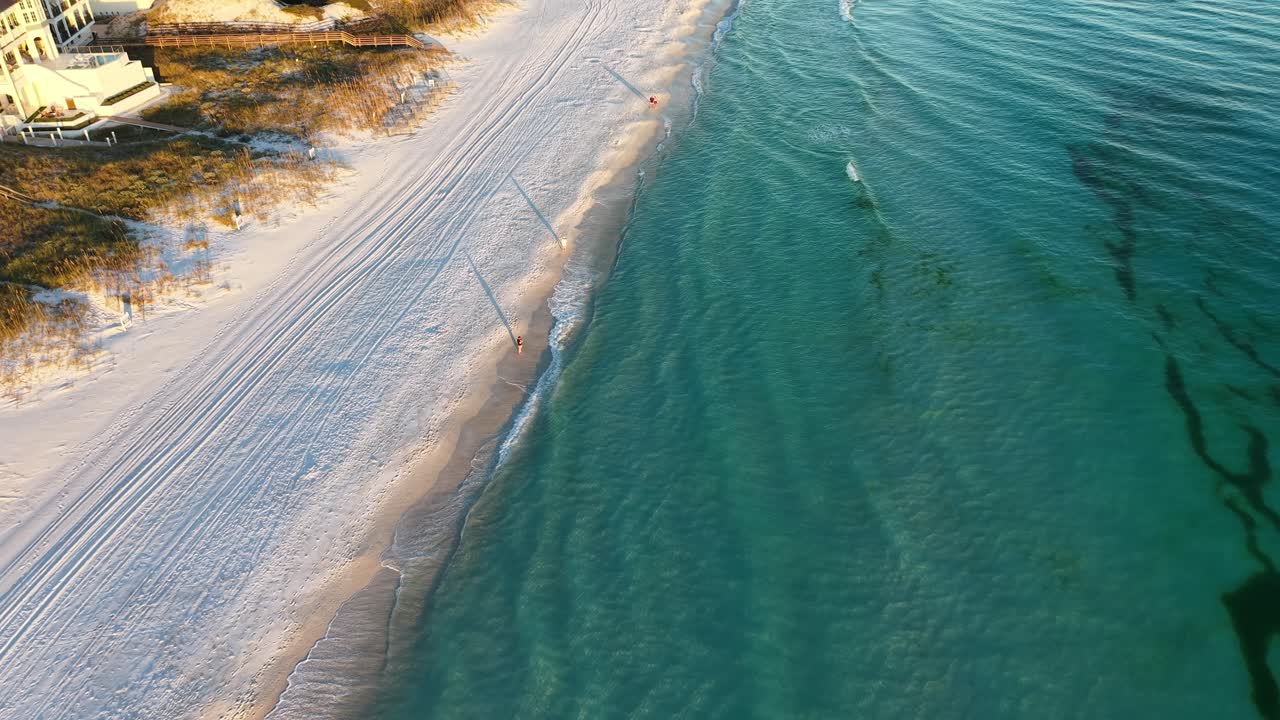 Amazing drone orbit over pristine white sandy beach with clear turquoise water and gentle waves, 30A, Florida, USA