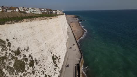 gente caminando en el camino por los acantilados del mar rottingdean en brighton, reino unido - antena