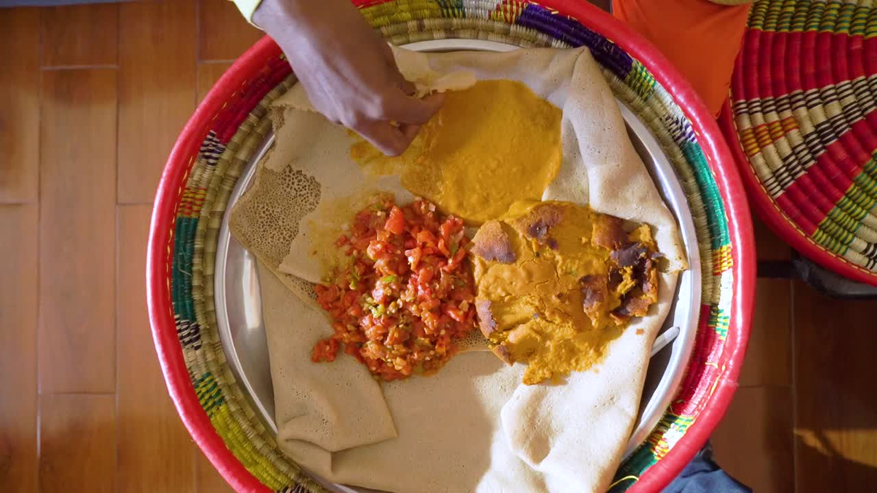 Un tradizionale pane etiope injera in un mesob con stufato, Etiopia