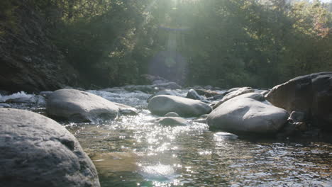 quick pan down from the blue sky to the rumbling waters of a creek in the morning