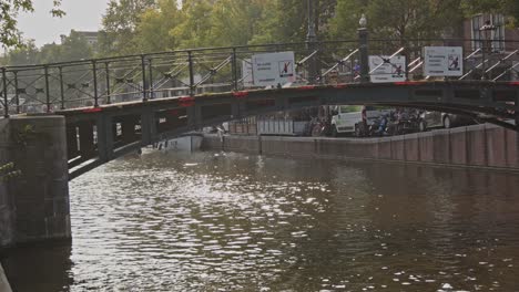 panning past bridge over canal with warning signs in the amsterdam red light district