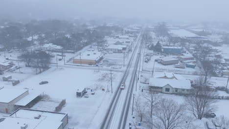 aerial footage flying over dodds ave during a snowstorm in chattanooga, tn with a car in a ditch.