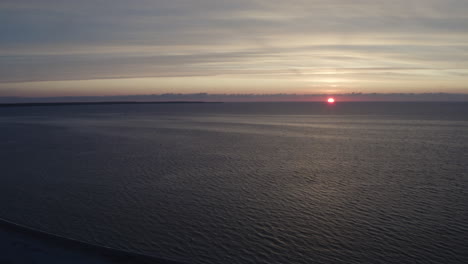 Toma-Aérea-De-4k-De-Una-Puesta-De-Sol-Dorada-Sobre-El-Agua-Del-Océano