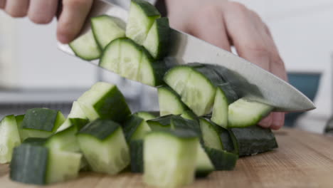 slow-motion shot as chopping, slicing up a cucumber in the kitchen