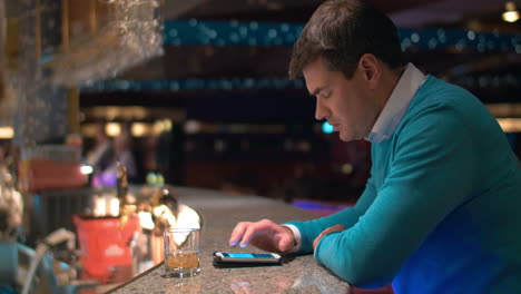 Joven-Escribiendo-Sms-En-El-Celular-En-El-Bar