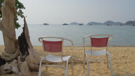 Sillas-En-La-Playa-Frente-Al-Mar-Azul-En-Labuan-Bajo,-Indonesia