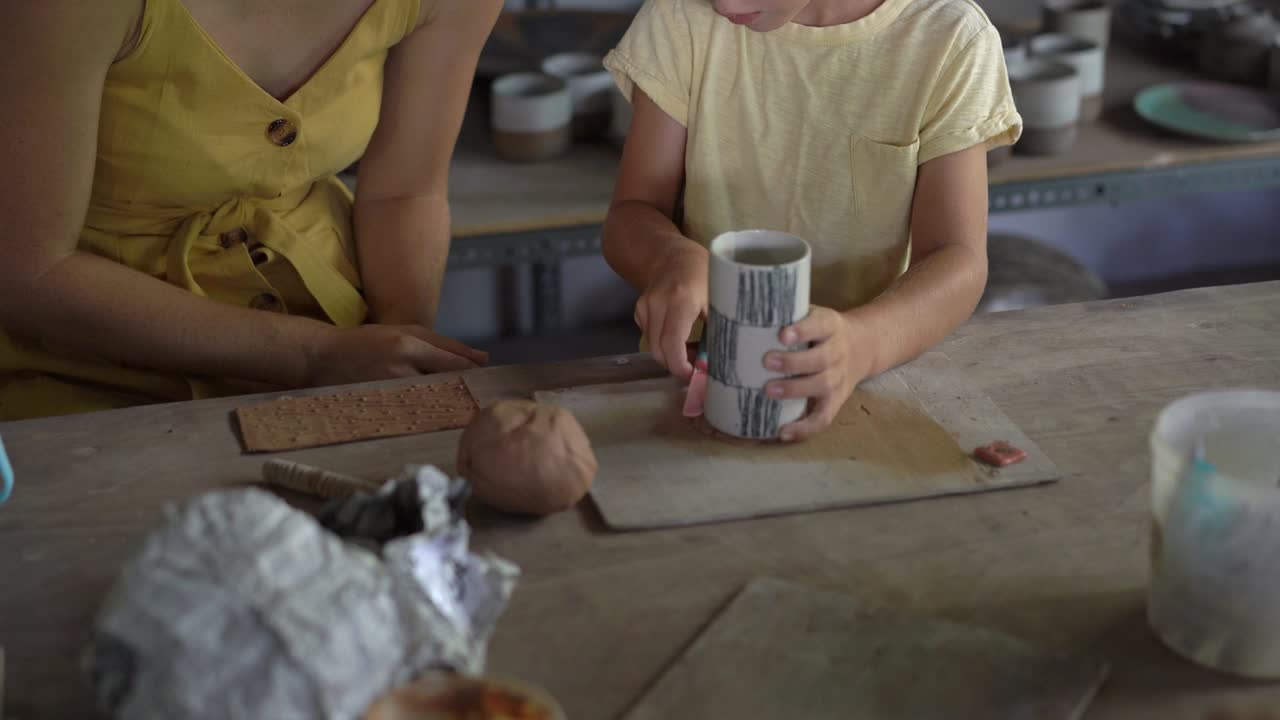una mujer joven y su pequeño hijo en una clase de cerámica