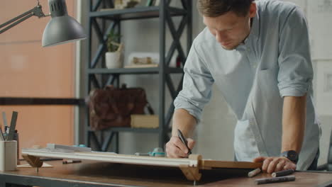 ingeniero trabaja en una oficina luminosa con una gran ventana se concentra y dibuja planos. lugar de trabajo de un arquitecto o diseñador: estilo loft dibujos interiores minimalistas