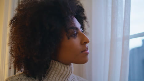 Tranquil-lady-looking-window-hotel-closeup.-Curly-hair-girl-staring-street-views