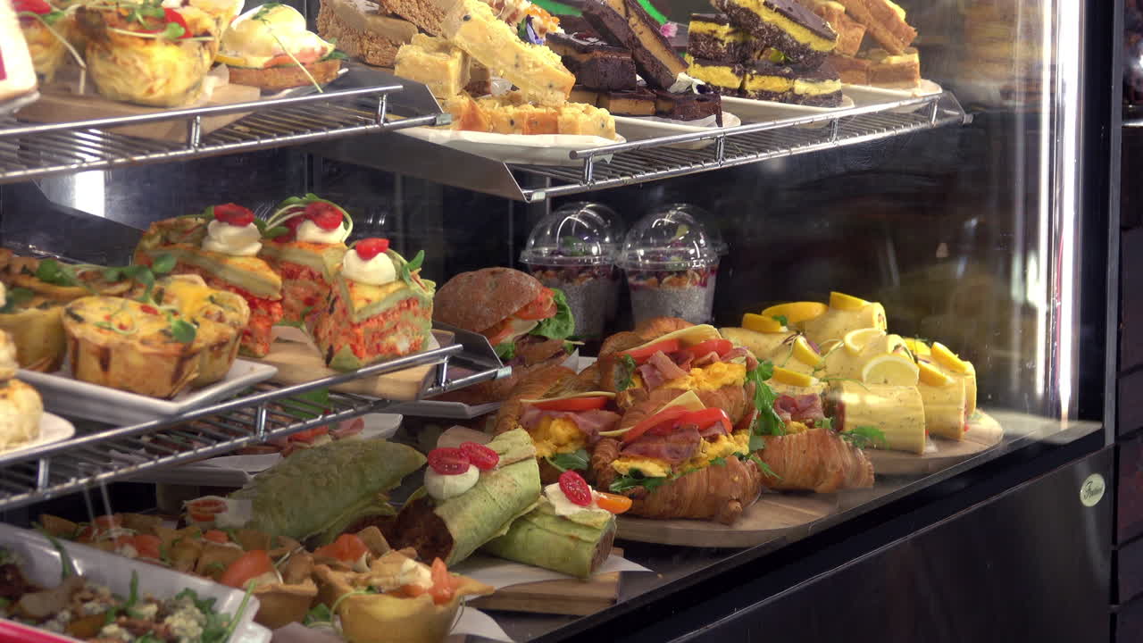 A sweeping wide shot of a food cabinet at a bakery or cafe