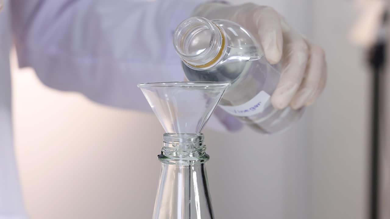 Pouring vinegar into a funnel for reaction
