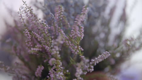 Female-hand-puts-a-bouquet-of-lavender-on-a-wooden-table