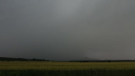 real time thunderstorm with lightning bolts illuminating the sky above rural countryside, extreme weather and climate change