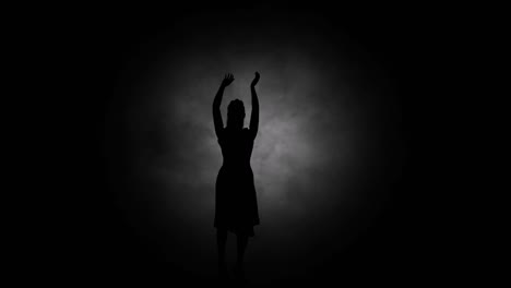 A-modern-youth-dance-performed-by-a-graceful-and-sexy-female-silhouette,-in-the-smoke-against-the-backdrop-of-spotlights