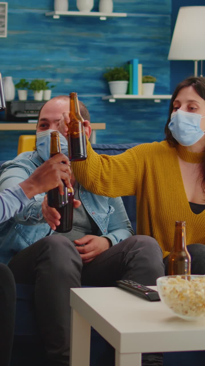 Vertical video: Diverse group of friends watching TV together comedy sitcom