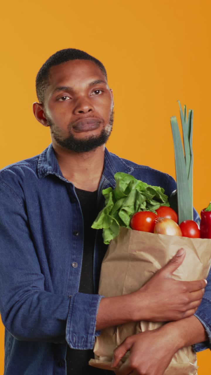Homem segurando sacola de papel cheia de vegetais frescos