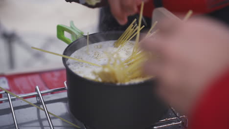 cocción de pasta en la olla de la estufa de campamento cocina al aire libre portátil para excursionistas y aventureros