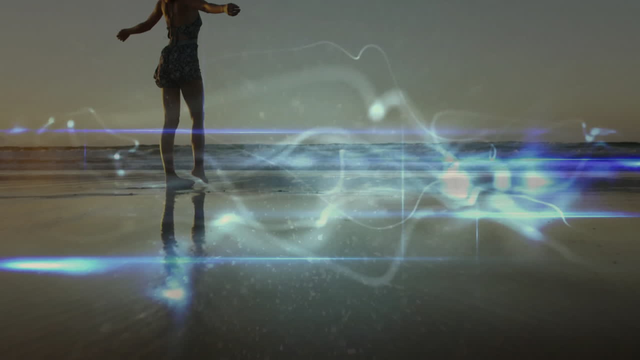 Walking on beach, person observing animation of glowing light patterns on sand