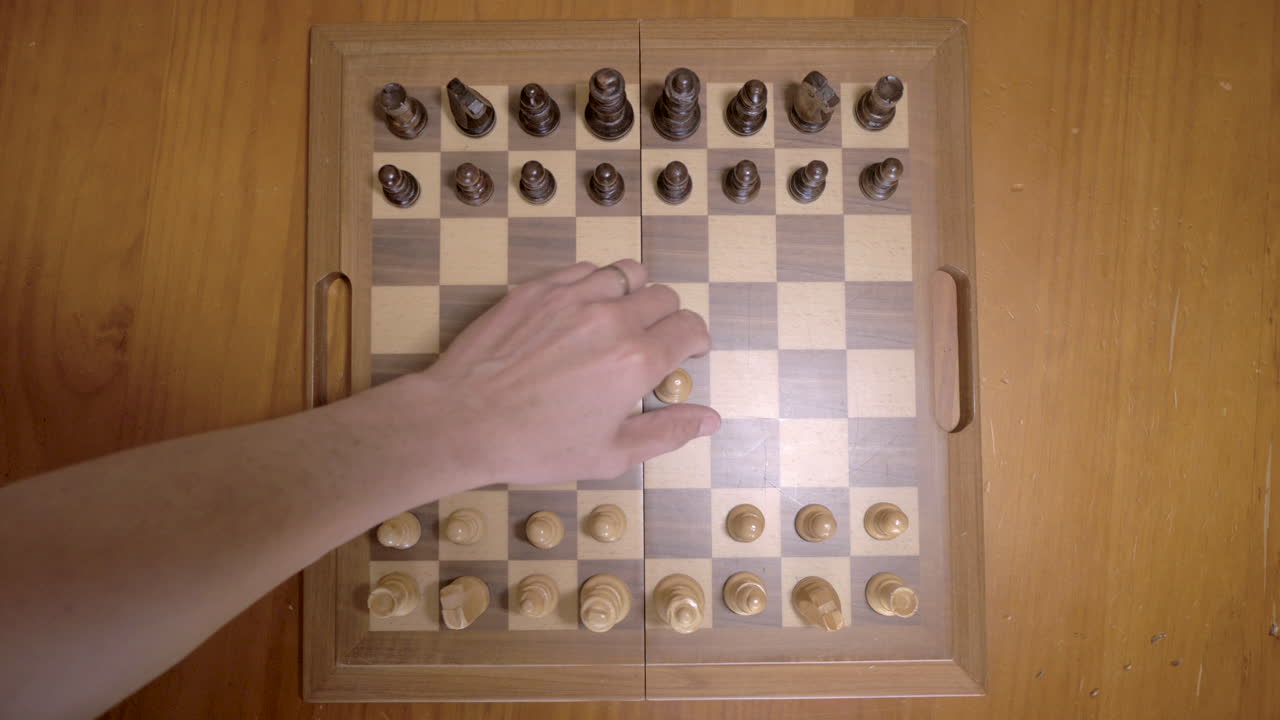 Top down view of a person starting a game of chess