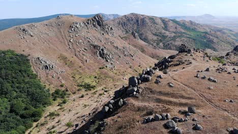 Aerial-View-Of-Macin-Mountain-Range-With-Crag-On-Steep-Slope-On-A-Sunny-Day-In-Dobrogea,-Romania