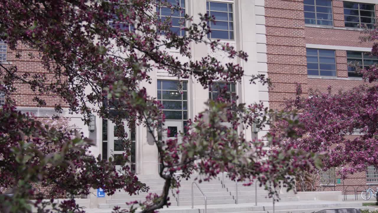 Jenison Fieldhouse on the campus of Michigan State University in East Lansing, Michigan in the spring with gimbal video moving down.