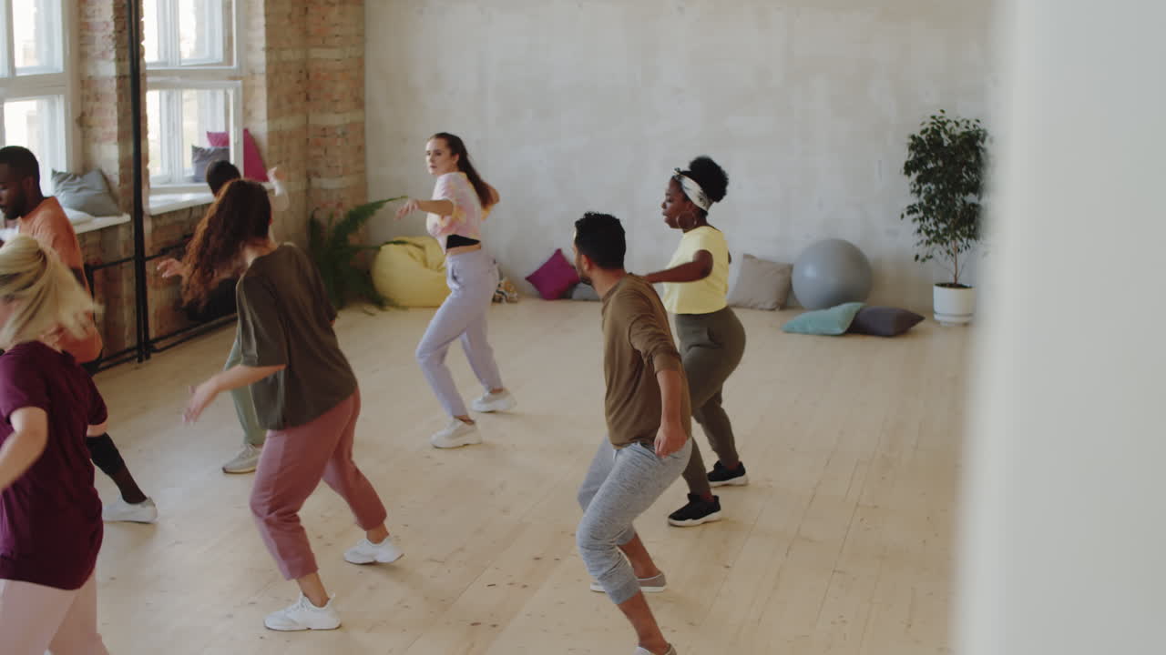 Treinadora dançando com grupo de alunos multiétnicos em estúdio