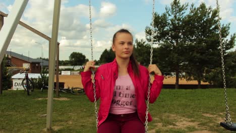 Girl-with-red-jacket-swinging-on-the-swing-set