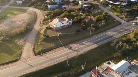 A-motorcycle-passing-by-on-the-road-near-the-front-next-to-the-Atlantic-Ocean-at-sunset-in-Uruguay-Punta-del-Este-Beach