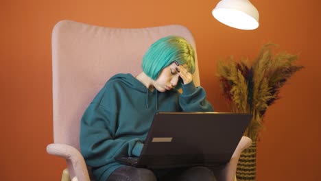 una mujer joven que trabaja en una computadora portátil tiene dolor de cabeza.