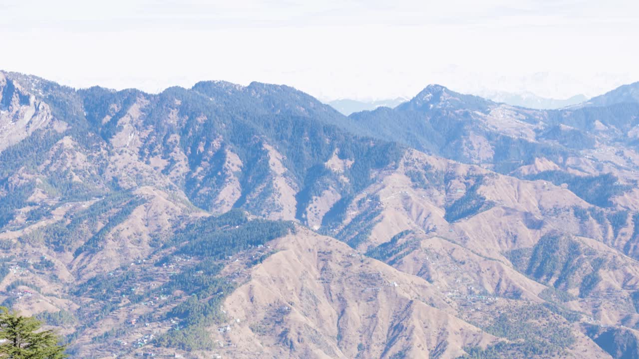 乾燥した山岳地帯に緑の森林が点在するパノラマビュー
