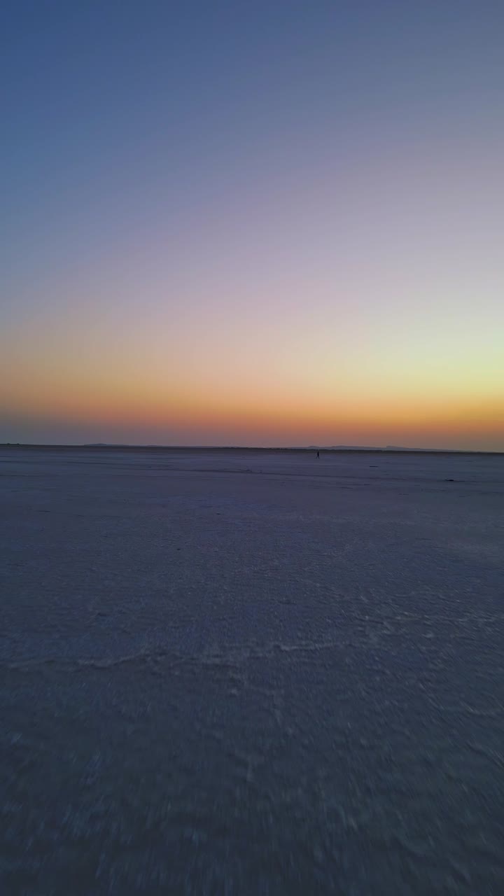 A forward-moving aerial view of the endless white Rann of Kutch in Gujarat a vast salt desert stretching endlessly beneath a glowing evening sky capturing the serene beauty of this natural wonder 4K