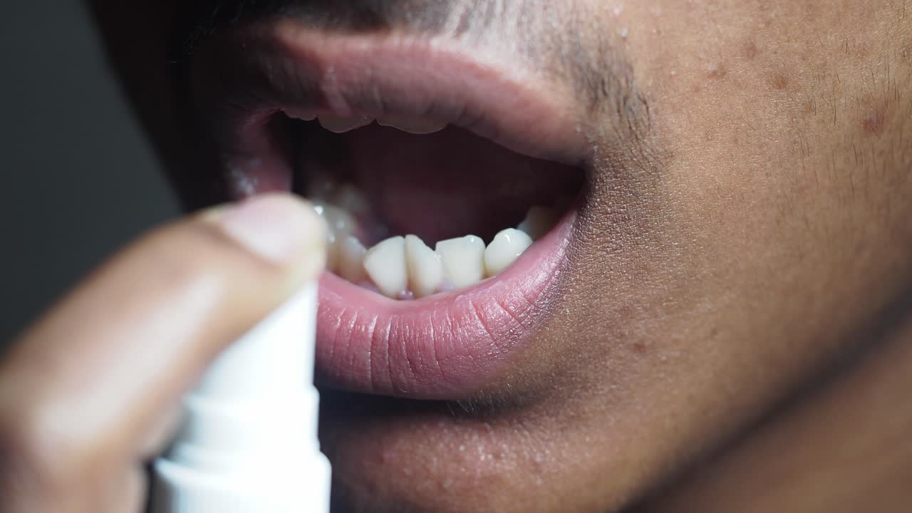 입 스프레이를 사용하는 사람