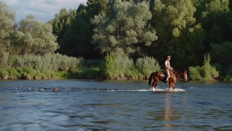 cowboy riding horse through river in forest