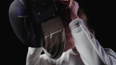 a fencer putting on their mask before a competition